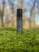 Roll-on bottle labeled 'Aromatherapy Moon' on a mossy surface with a blurred natural background