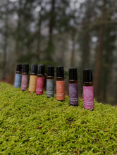 8 brightly labelled aromatherapy rollers from Bohobo Aromatherapies on moss in a woodland