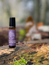 amber bottle with purple label off the top of my head on a log in a woodland
