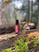 amber bottle with red lable on log in a woodland